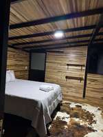 Cama de la cabaña Bosque de Loros con toallas dobladas