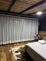 Zona de estar de Bosque de Loros con cortinas y rack de vinos