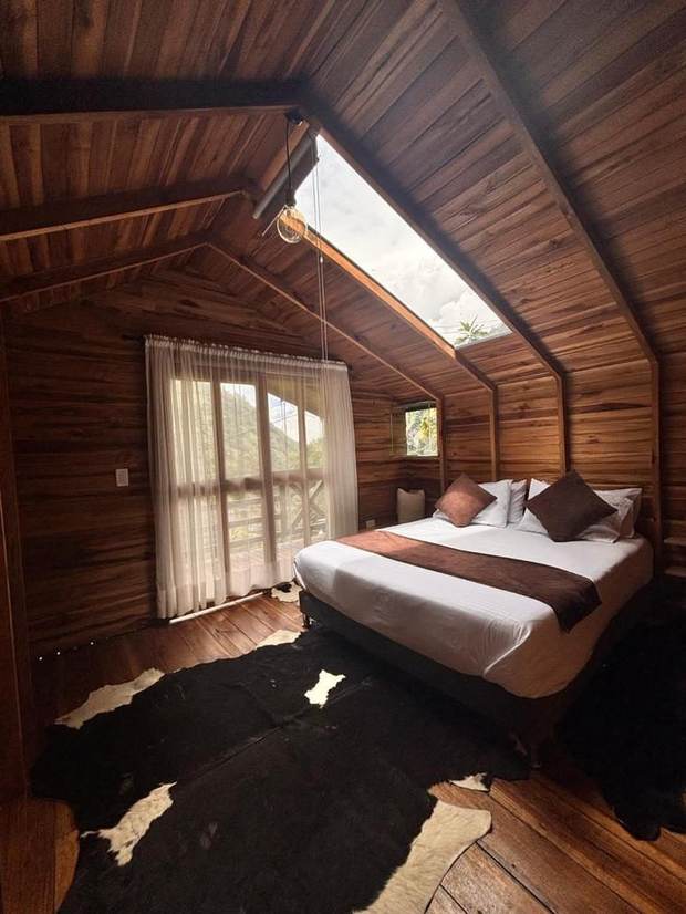 Habitación de la cabaña Dulce Bourbon con claraboya y cama con vista al balcón