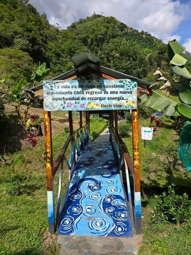 Puente de acceso pintado con mural y frase de bienvenida