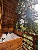 Jacuzzi interior de Refugio del Viento bajo techo de vidrio con vista a los árboles
